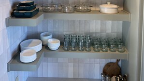 Une cuisine avec des étagères en bois, des récipients en verre et un plafond en bois.