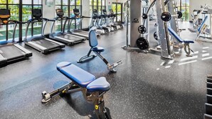 A gym with treadmills, weight machines, and benches.