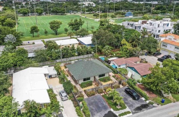 An aerial view of a residential area with houses, a sports field, and a small parking area. - ⭐️Beautiful Duplex in Victoria Park!⭐️ (Fort Lauderdale)