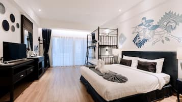 Una habitación de hotel moderna con una cama grande, un escritorio, un televisor y un balcón con vistas.