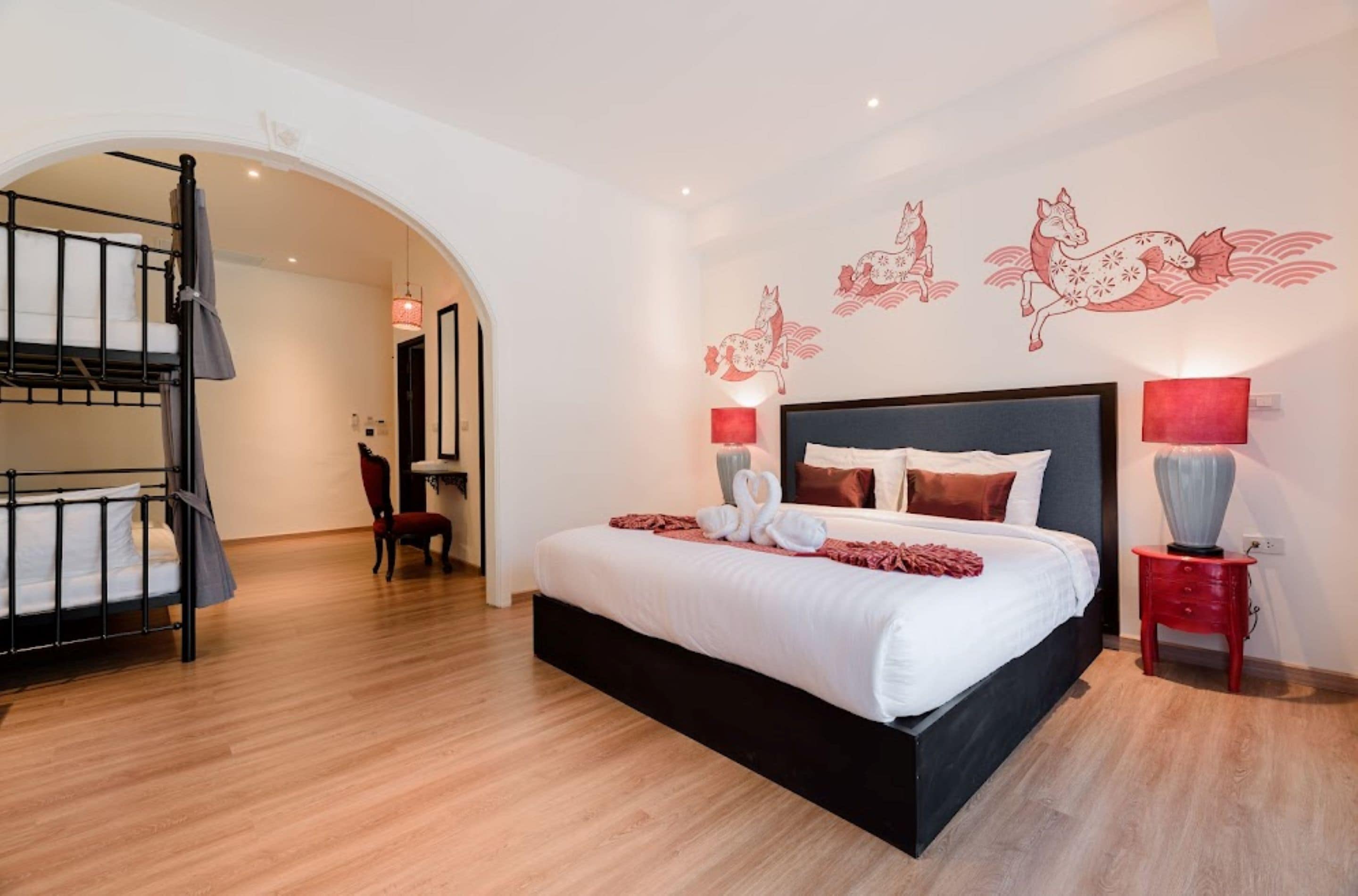 Un dormitorio moderno con una cama grande, un escritorio pequeño y una silla. Una escalera conduce a un nivel superior.