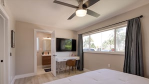 A bedroom with a bed, a desk, a chair, a ceiling fan, and a TV. - Paradise 4 min to Beach with Heated Pool and Spa (Deerfield Beach)
