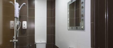 Un baño con inodoro, lavamanos y ducha.