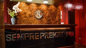 Ein Empfangsschalter mit der Beschilderung 'SEMPRE PREMIER INN' und einem Logo darüber.