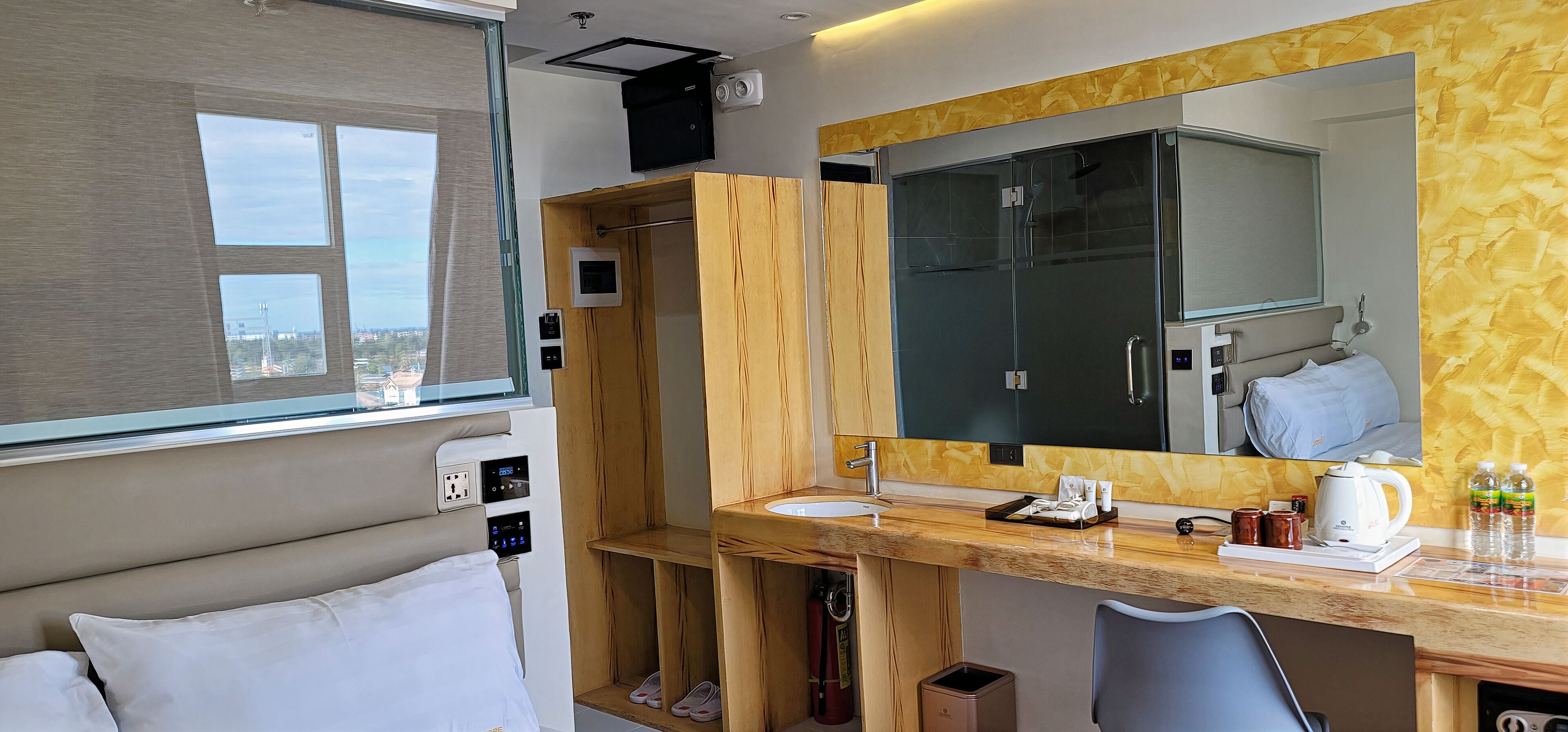 A modern bathroom with a large mirror, wooden vanity, and a shower enclosure.