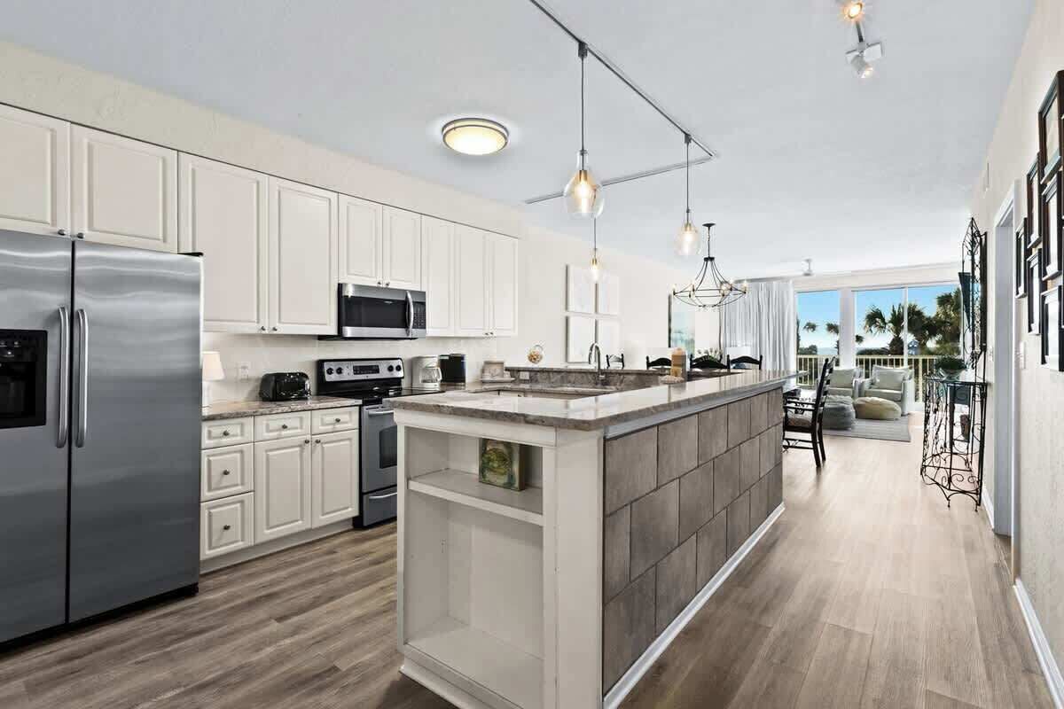 Een moderne keuken met witte kastjes, roestvrijstalen apparatuur en een centraal eiland.