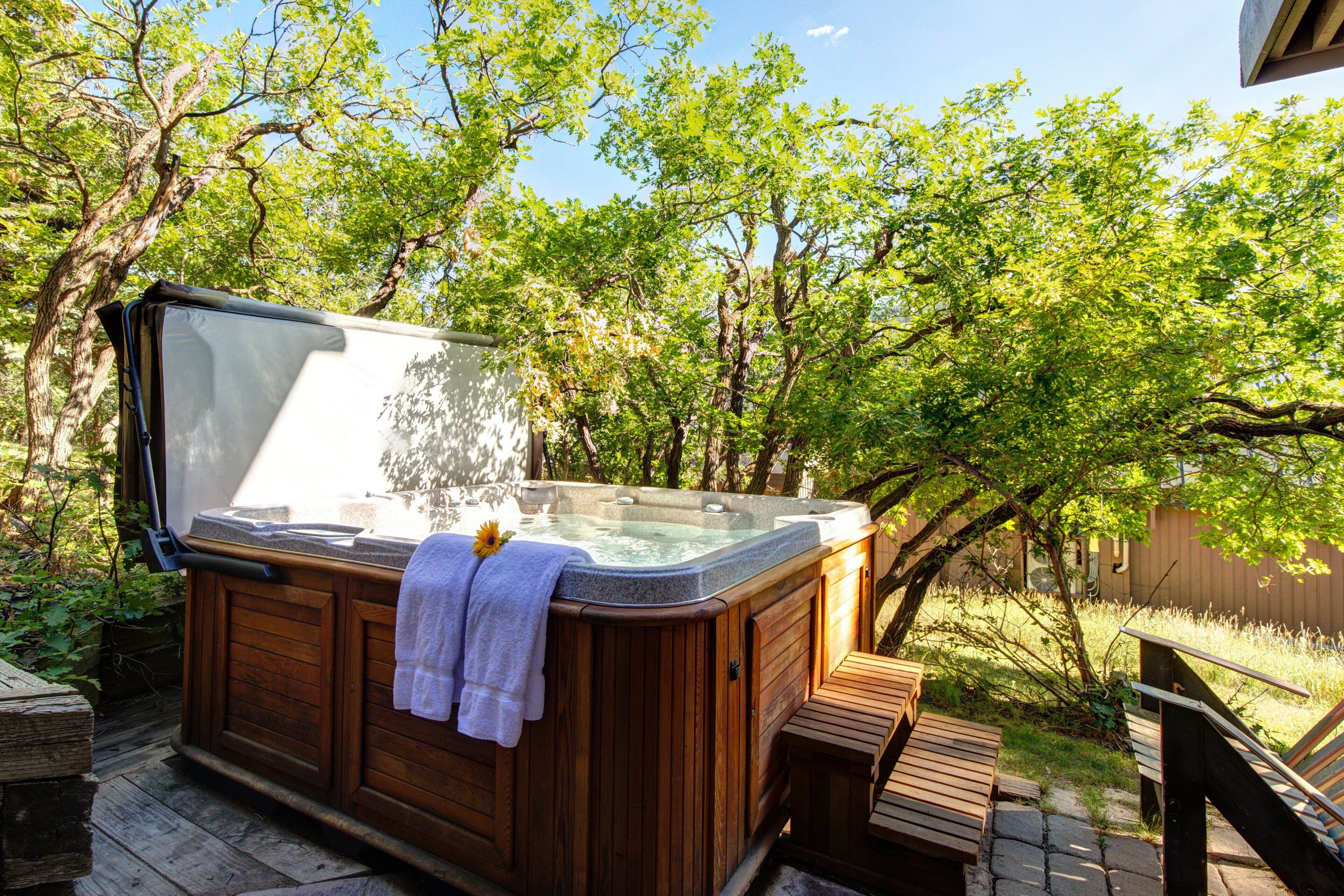Un jacuzzi con revestimiento de madera, una banca y una terraza de madera.
