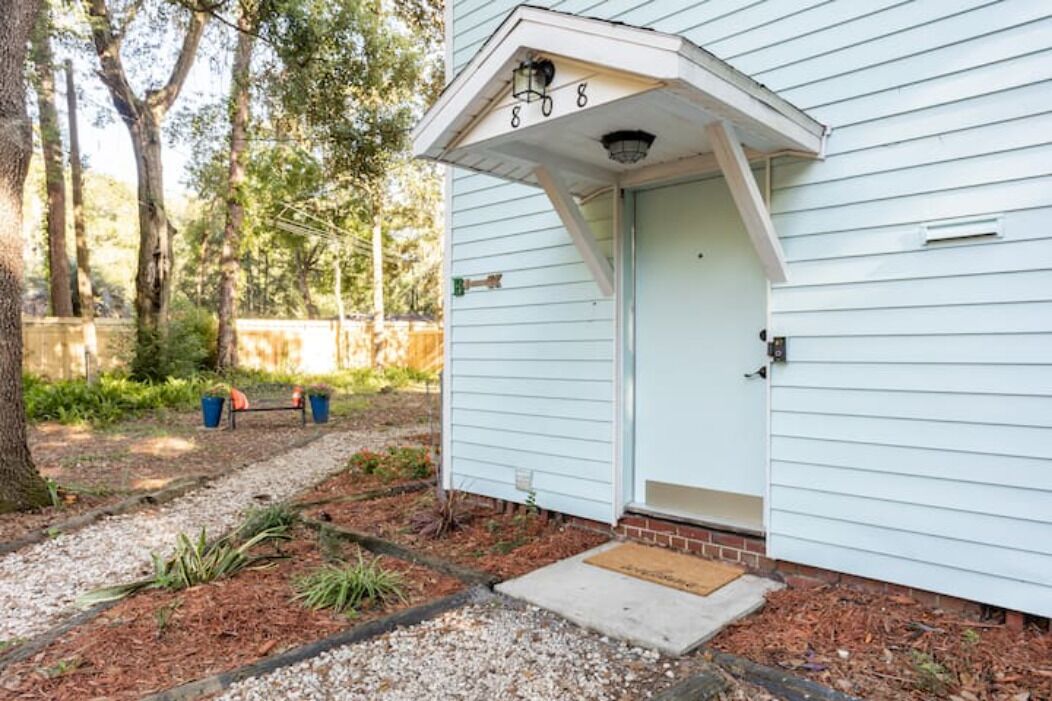 A house with a white exterior, a front door, and a small porch area.