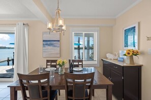 A dining area with a table, chairs, and a chandelier.
