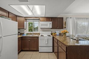 A kitchen with a microwave, stove, and refrigerator.