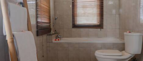 A bathroom with a toilet, bathtub, and shower.