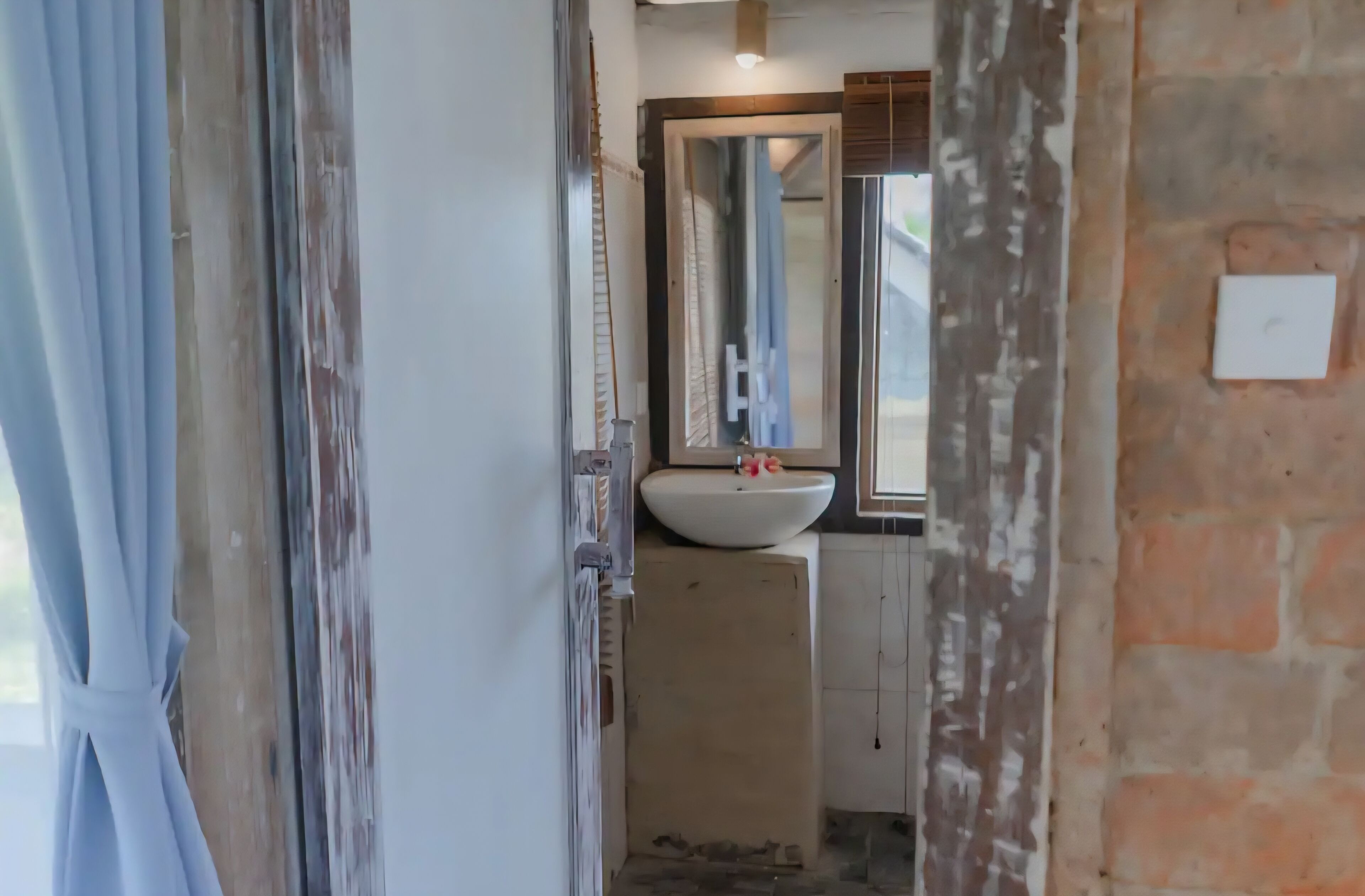 A bathroom with a white sink, a mirror, and a wooden cabinet.