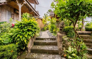 Uma casa de madeira tradicional com uma escadaria de pedra que leva a uma varanda.
