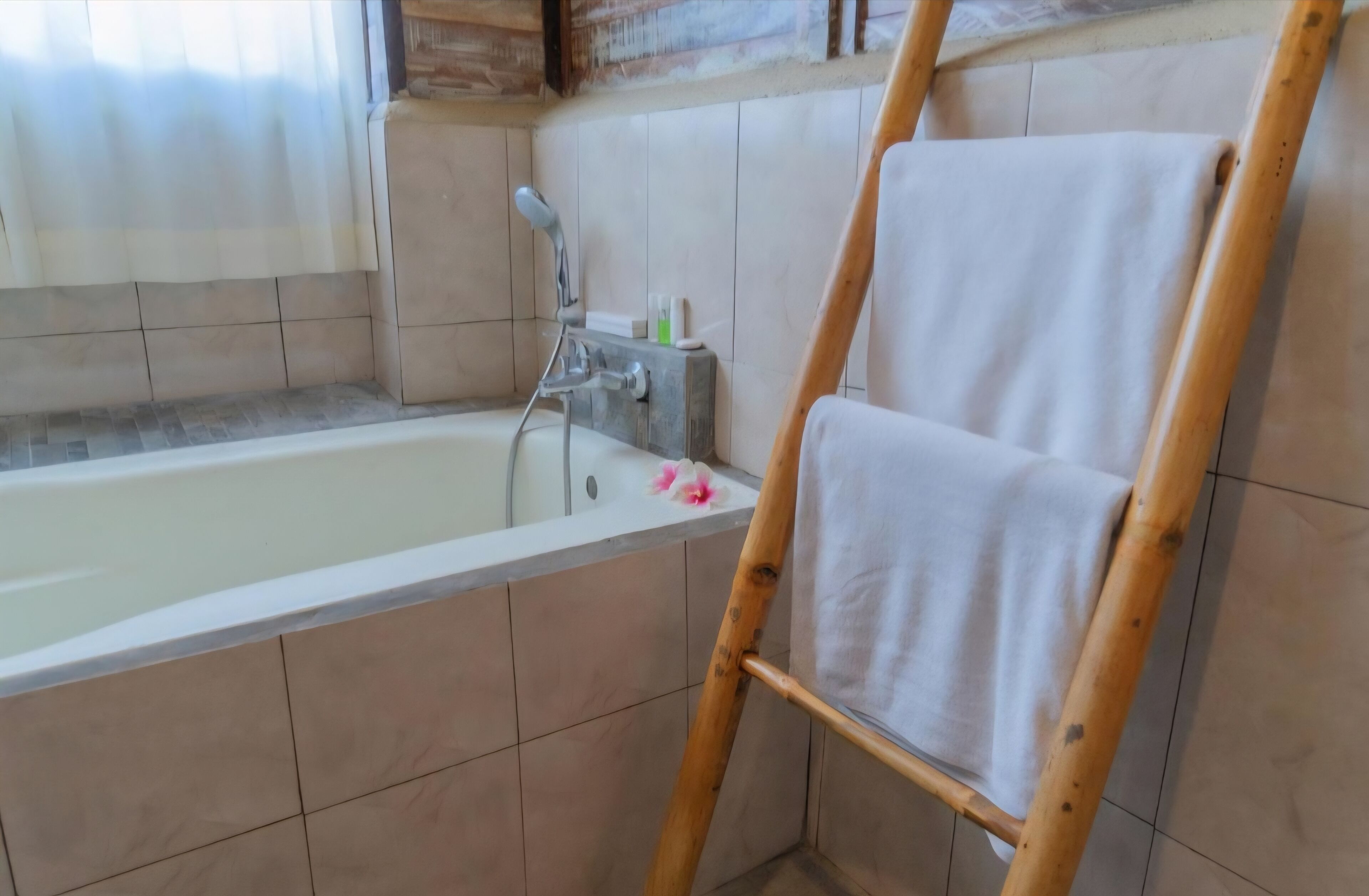 A bathroom with a bathtub, a wooden ladder, and a towel rack.