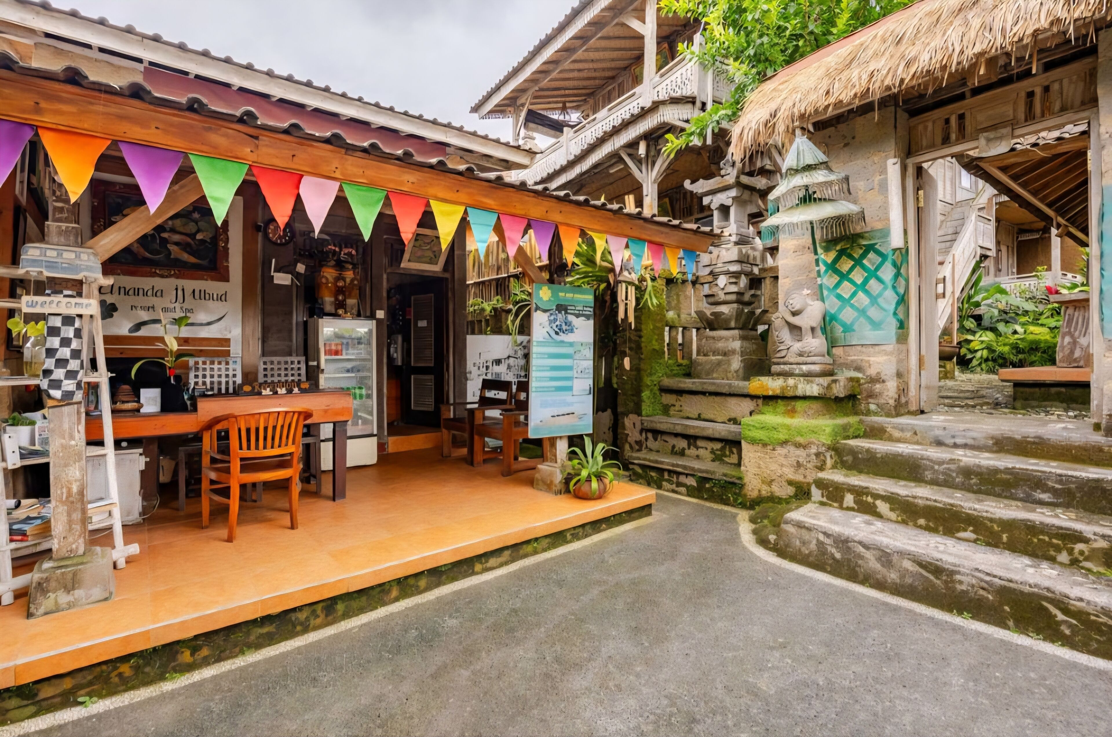 A traditional wooden building with a thatched roof, a wooden bench, and a small table with chairs outside.