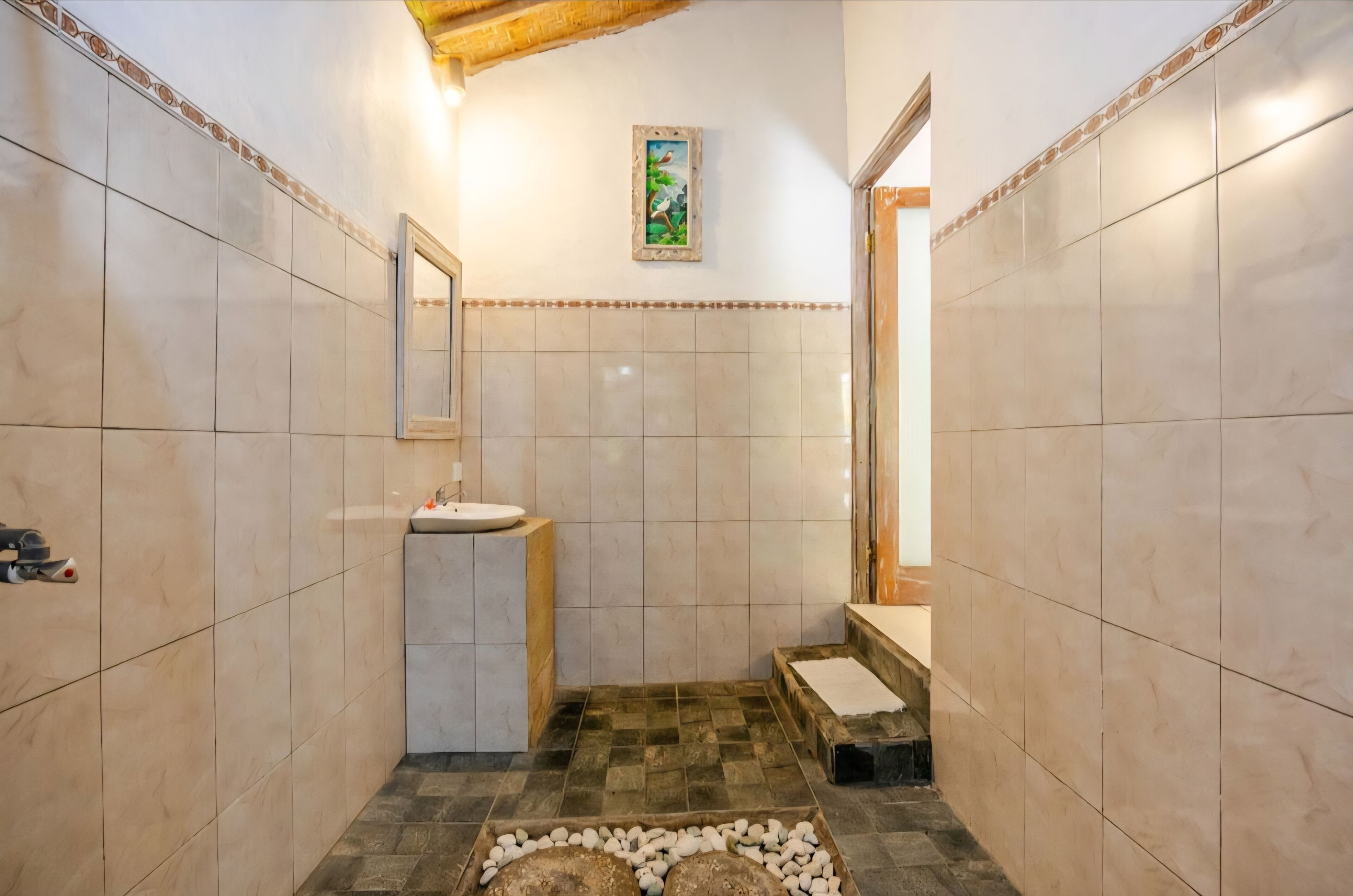 A bathroom with a sink, mirror, and tiled walls.