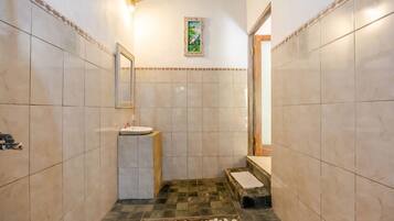 A bathroom with a sink, mirror, and tiled walls.