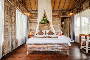 Um quarto rústico de madeira com cama, cortinas e janela.