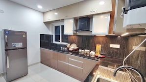 Una cocina moderna con electrodomésticos de acero inoxidable, encimera negra y pileta integrada.