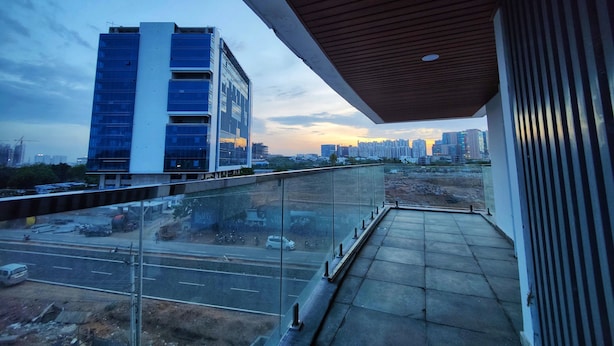 Un balcón con vistas a un paisaje urbano al atardecer.