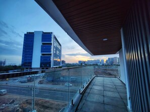 A balcony with a view of a cityscape during sunset.