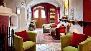 Una sala acogedora con chimenea, un sofá rojo y un sillón verde.