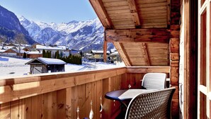 Un balcón de madera con vistas a montañas nevadas.