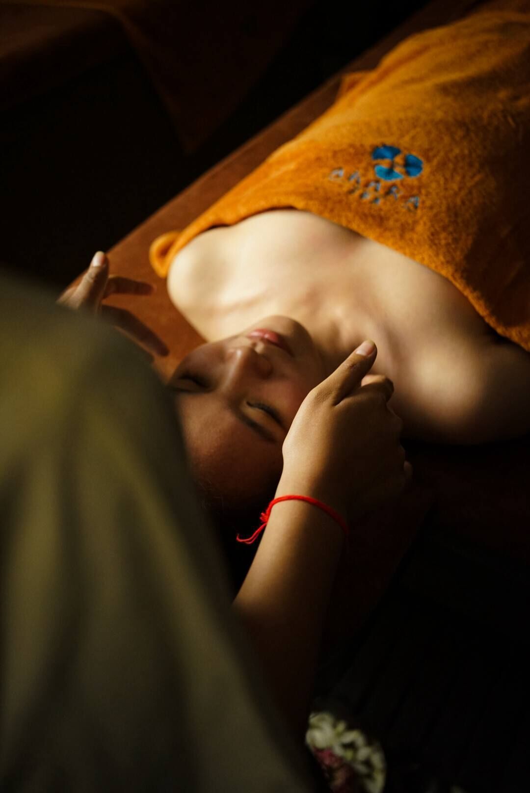 A person lying down with a blanket covering their head.