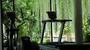 An indoor gym with exercise equipment and lush green plants. - Hotel Vellita Siem Reap (Siem Reap)