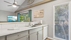 Una cucina moderna con un'ampia finestra, una ventola a soffitto e un cartello di benvenuto.