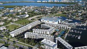 A coastal hotel with multiple buildings, a marina, and a view of the ocean. - Cozy 1-bedroom condo with pool access (Marco Island)