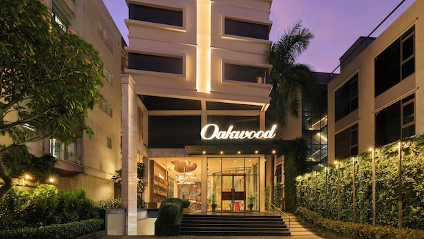 A hotel entrance with a sign reading 'Oakwood,' steps leading up to the entrance, and a well-lit facade. - Oakwood Hotel & Apartments Saigon (Ho Chi Minh City)