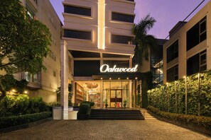 A hotel entrance with a sign reading 'Oakwood,' steps leading up to the entrance, and a well-lit facade.