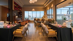 A modern dining area with high ceilings, large windows, and a city view. - Oakwood Hotel & Apartments Saigon (Ho Chi Minh City)