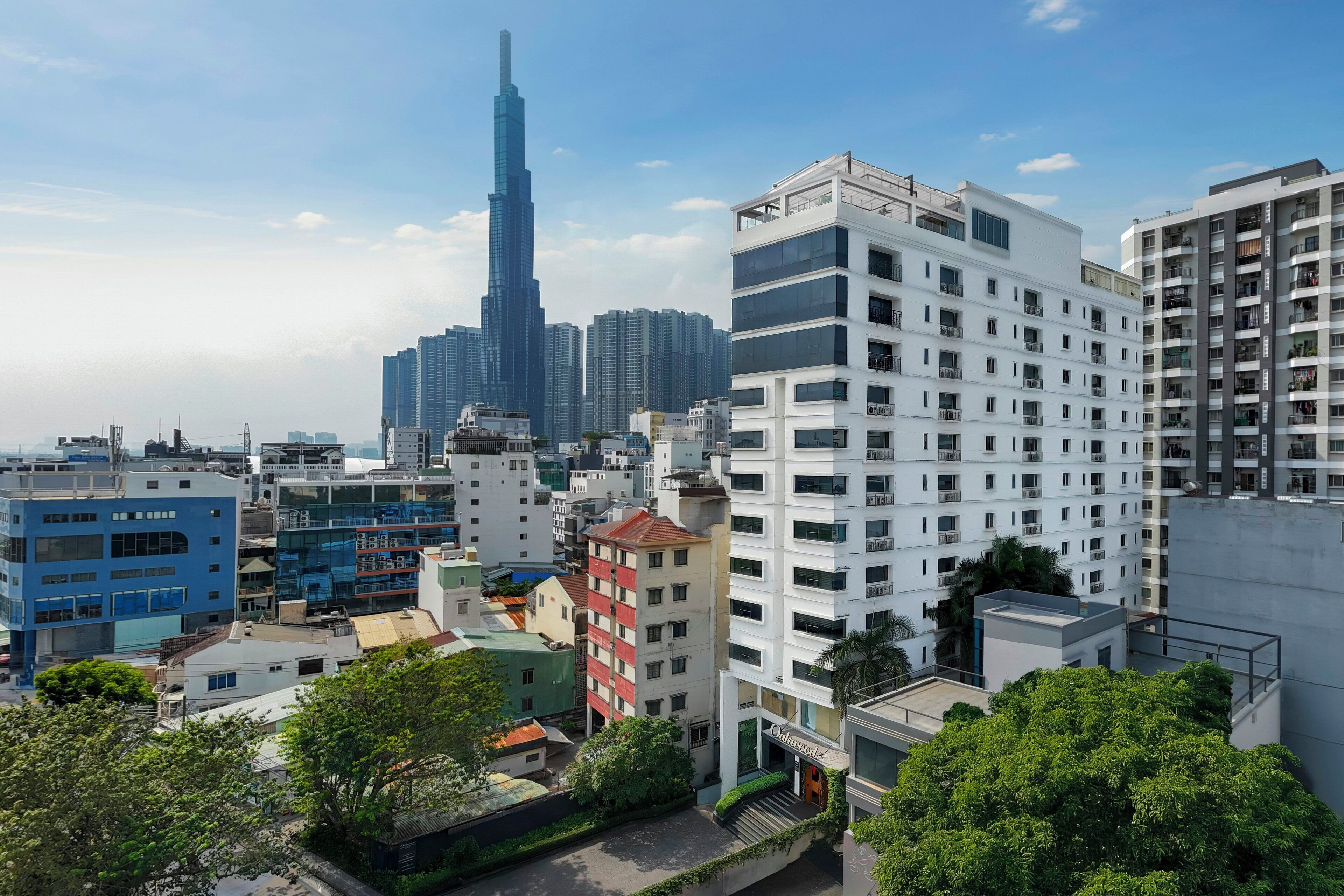 Un paisaje urbano con edificios modernos, entre ellos un rascacielos destacado.