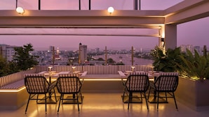 A rooftop terrace with a city view, seating area, and ambient lighting. - Oakwood Hotel & Apartments Saigon (Ho Chi Minh City)