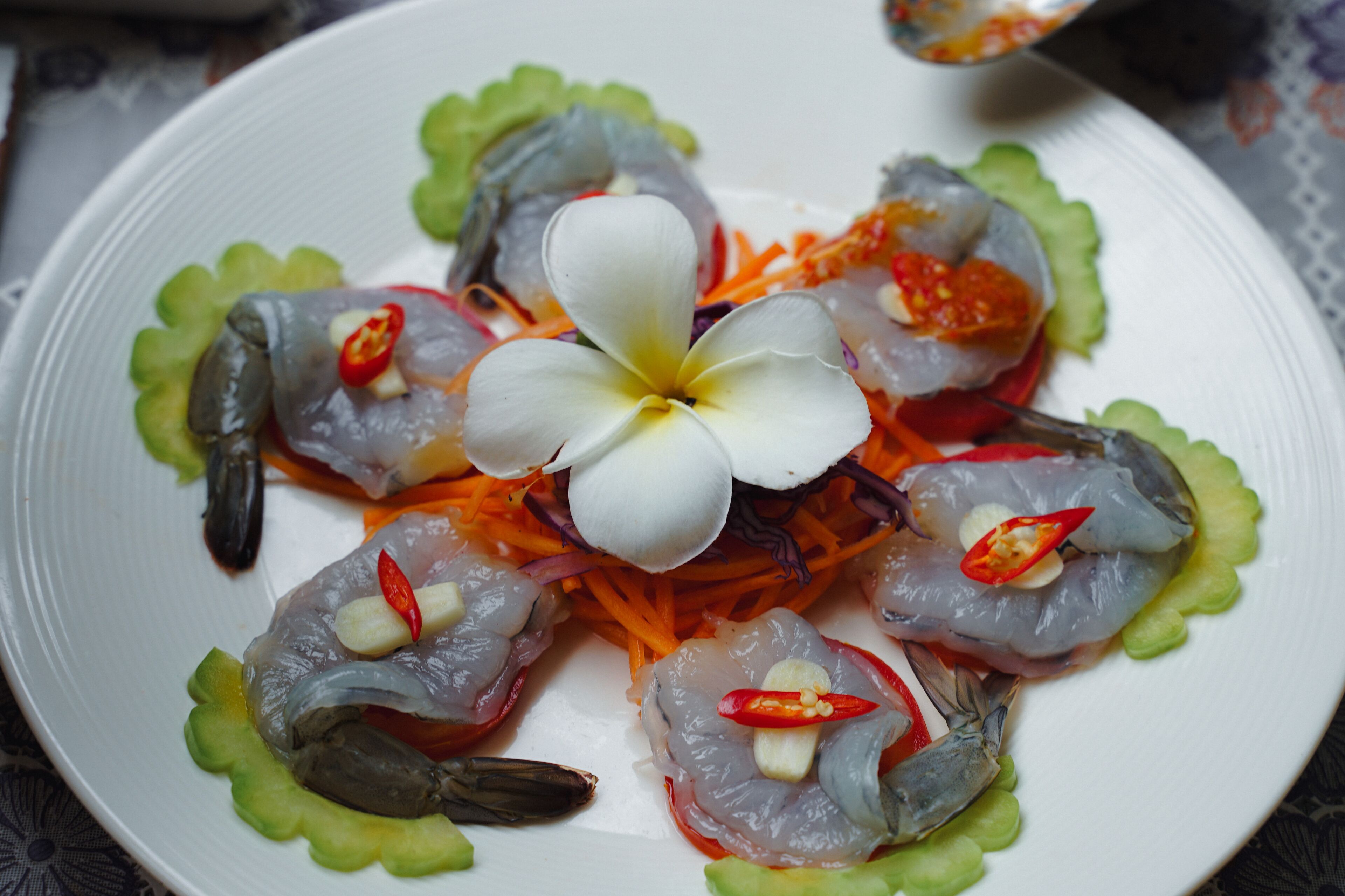 A plate of sashimi with a flower garnish.