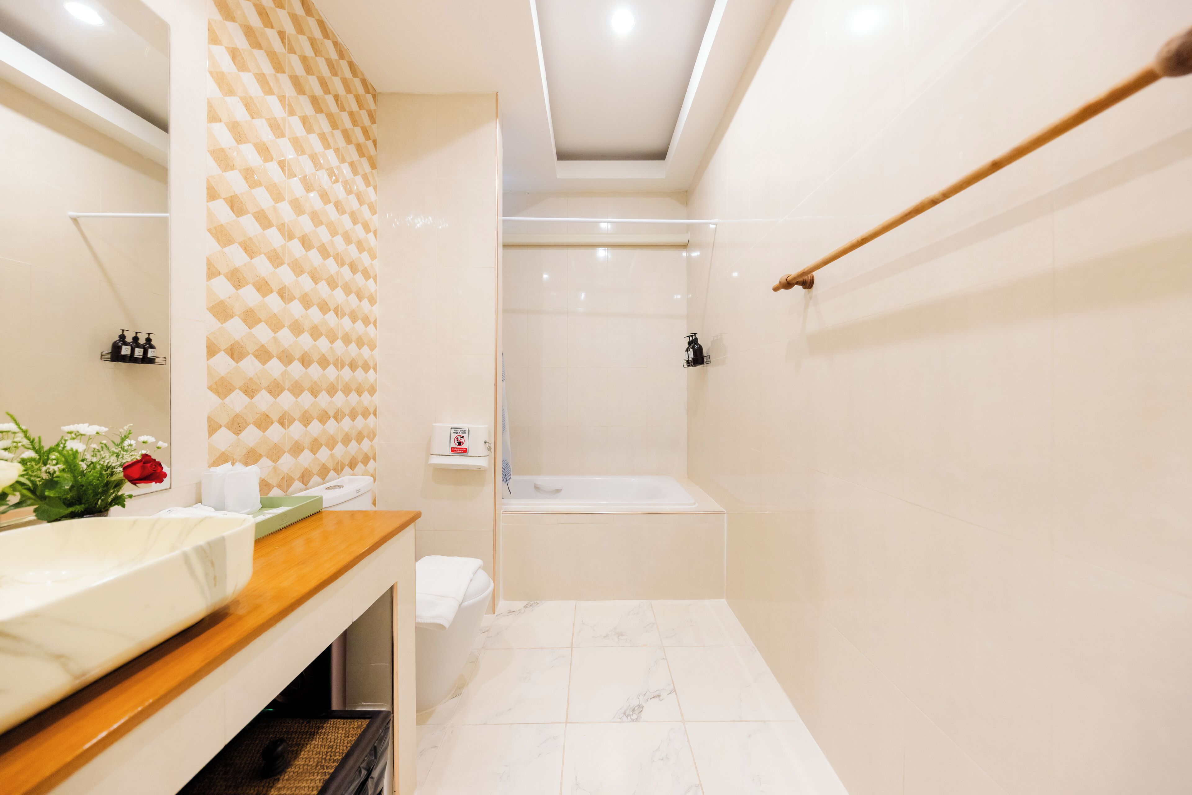A modern bathroom with a wooden vanity, a shower, and a tiled floor.