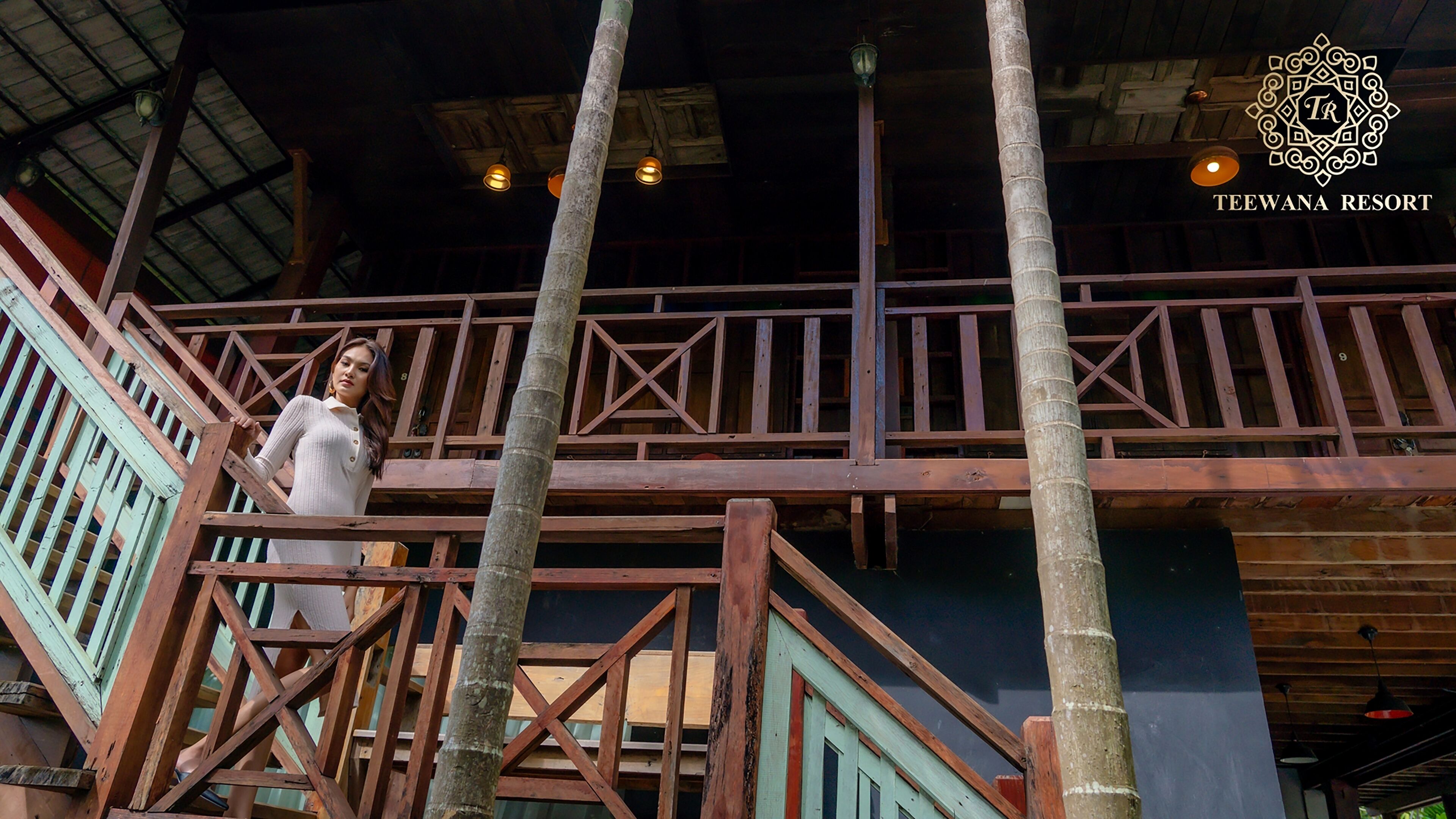 A wooden balcony with a person standing on it.