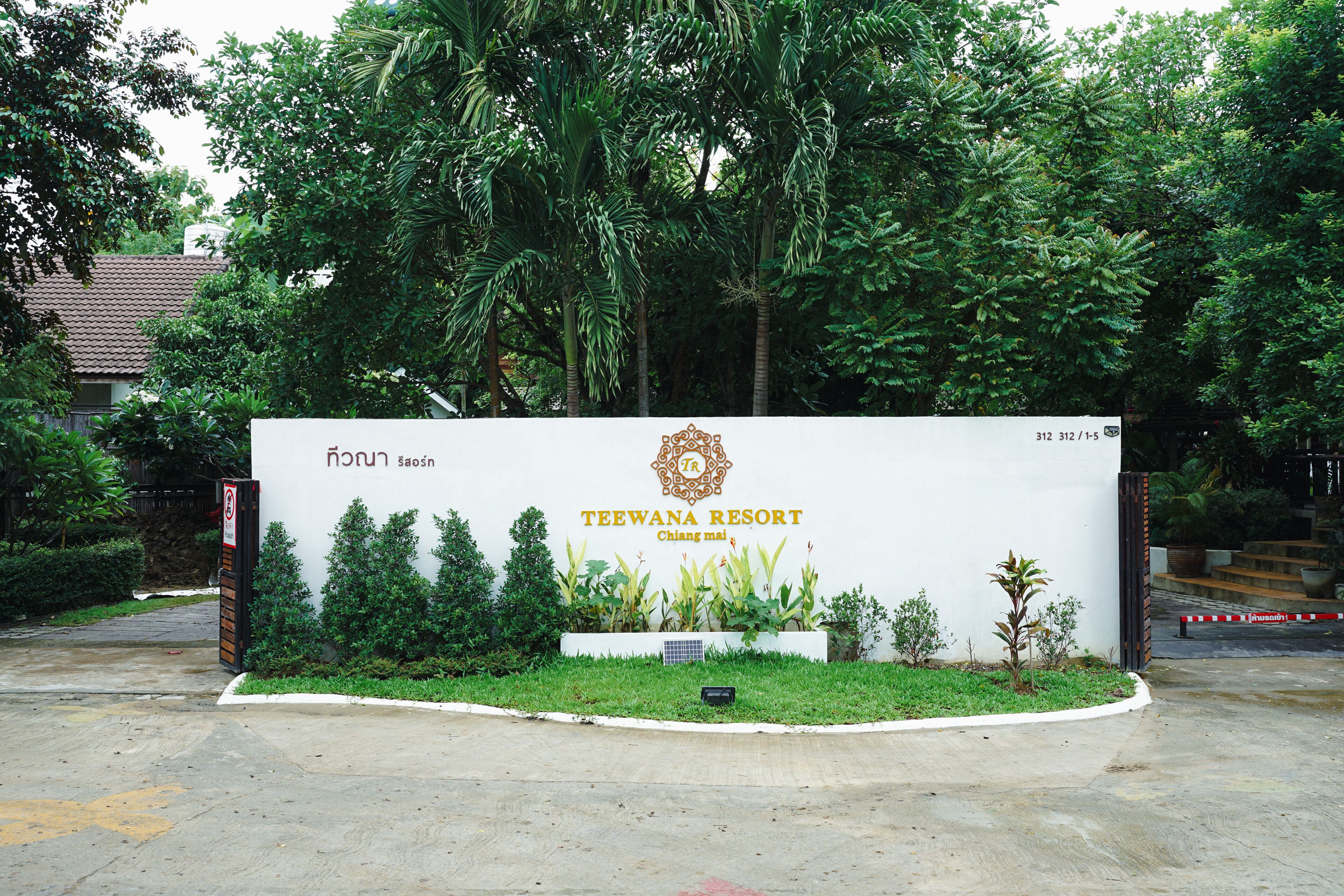 A sign for Teewana Resort with a logo, name, and address.