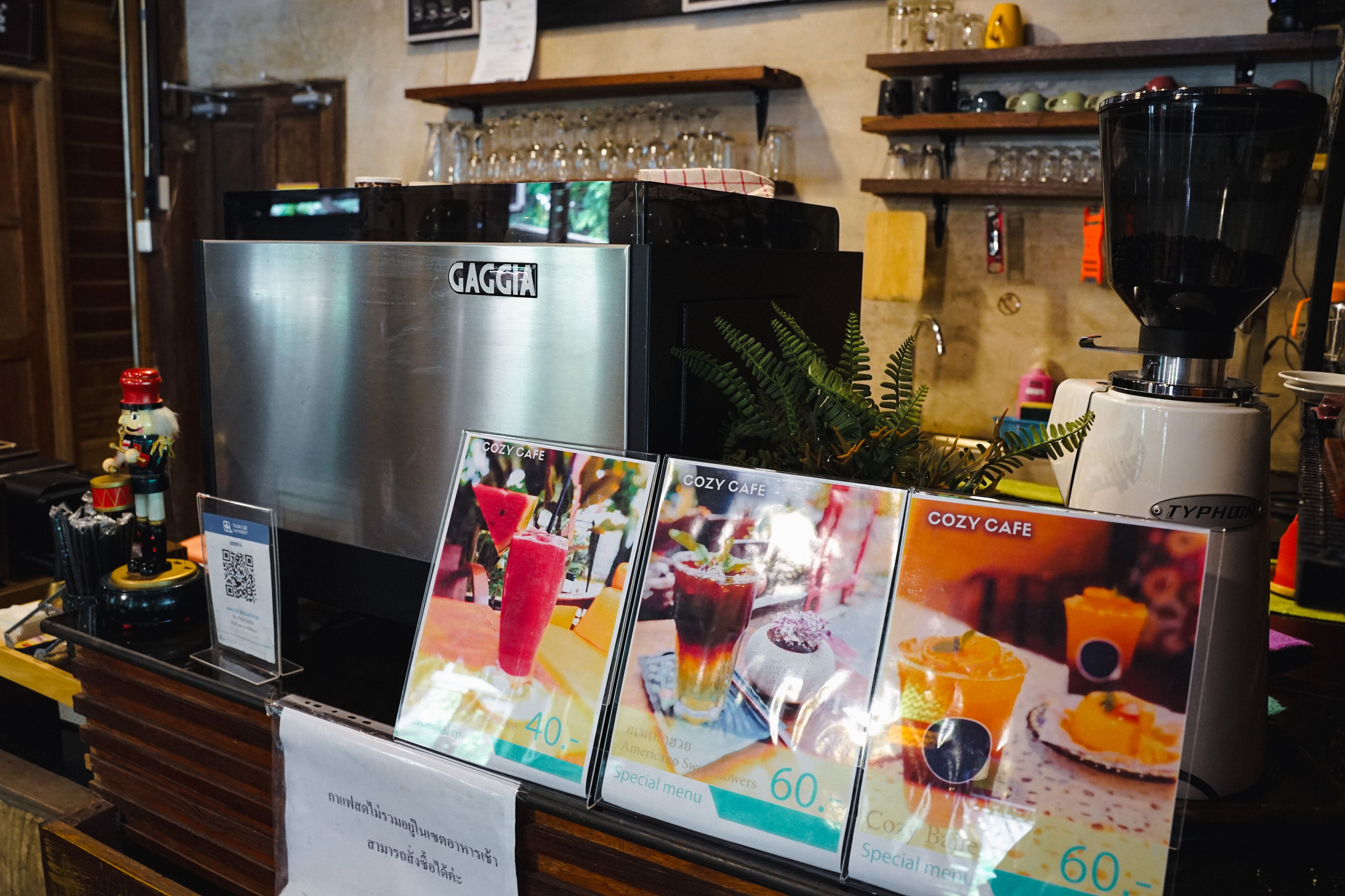 En Gaggia espressomaskine i en café, med menutavler der viser specialitetsdrikke til henholdsvis 40 og 60.