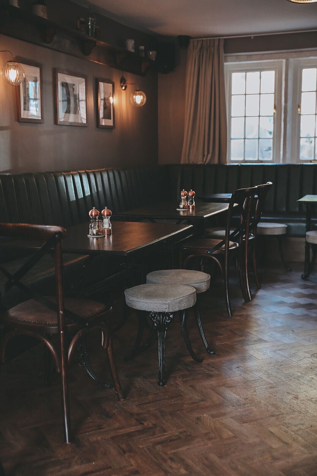 Ein gemütliches Restaurant mit Holztisch, gepolsterten Stühlen und einer Bank.