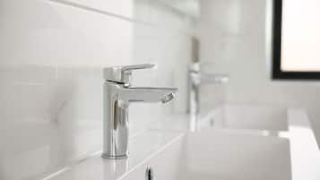 A modern bathroom with a chrome faucet and a white sink.