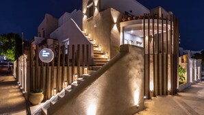 Un edificio moderno con una escalera espiral, una cerca de madera y un cartel dando la bienvenida a los huéspedes.