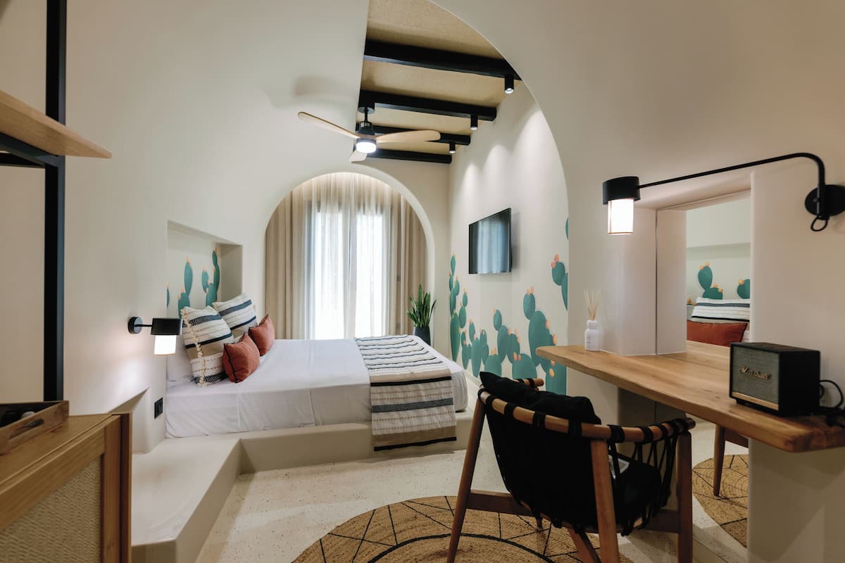 Un dormitorio moderno con cama, escritorio, silla y ventilador de techo.