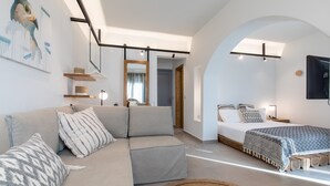 Un dormitorio moderno con sofá, cama y un espejo grande.