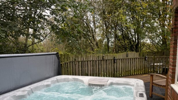 A hot tub in a backyard with a wooden fence and trees in the background. - Blaydonburn - Sleeps 4,5 - Parking - Hottub - Yard (Blaydon on Tyne)