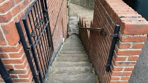 A narrow brick staircase leading to a gated area with a metal gate and a wooden gate. - Blaydonburn - Sleeps 4,5 - Parking - Hottub - Yard (Blaydon on Tyne)