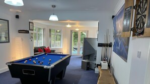 A pool table with balls, a dartboard, and a billiards cue rack in a room with a blue carpet, a sofa, and a door leading outside. - Blaydonburn - Sleeps 4,5 - Parking - Hottub - Yard (Blaydon on Tyne)
