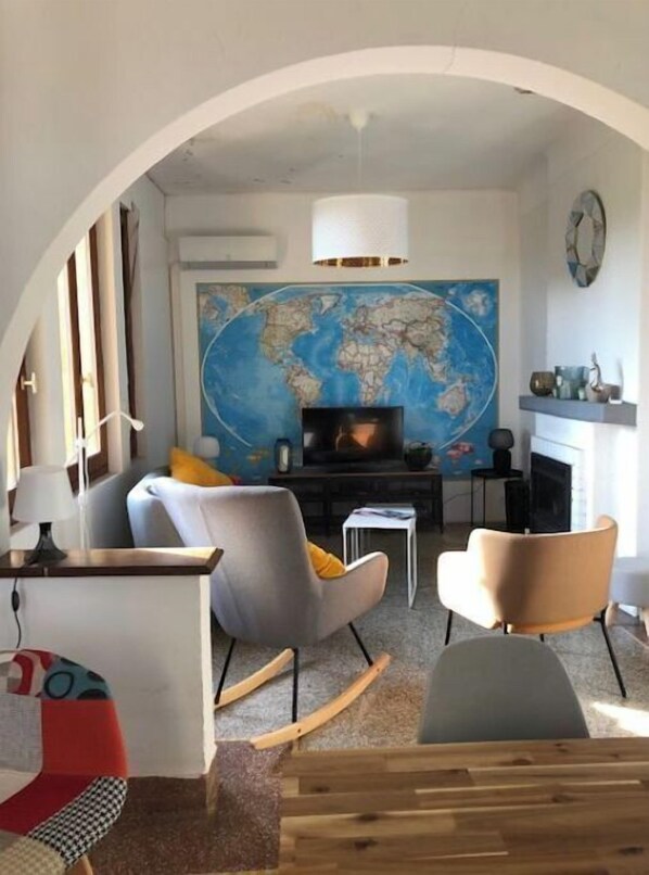 A living room with a large world map, a television, and modern furniture.